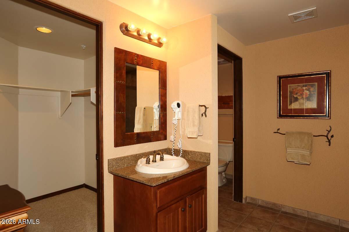 36601 North Mule Train Road, Unit 13D Carefree, AZ 85377 - Photo 26 of 51 a bathroom with a sink and mirror with wooden floor