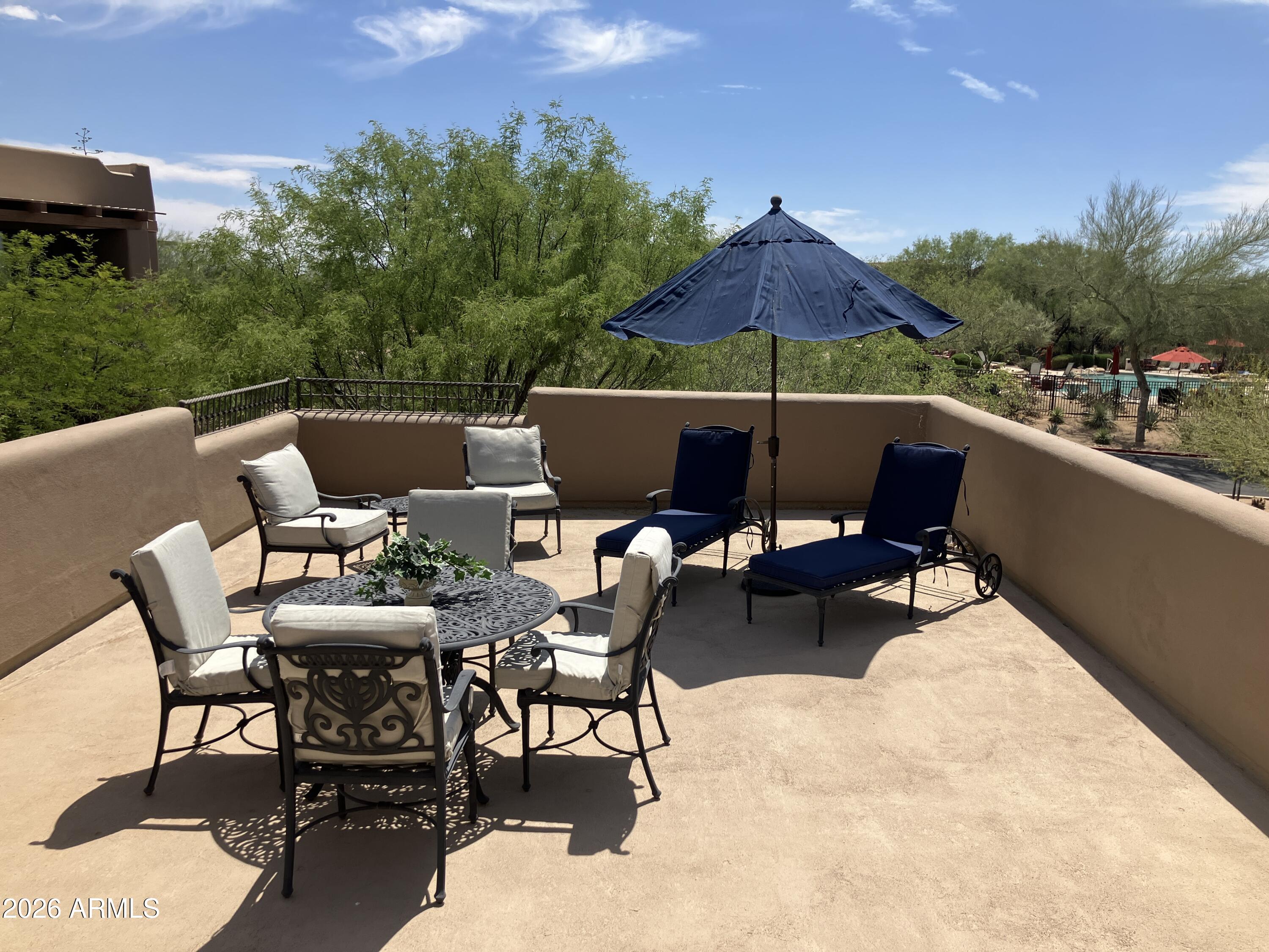 36601 North Mule Train Road, Unit 13D Carefree, AZ 85377 - Photo 30 of 51 a roof deck with a table and chairs under an umbrella