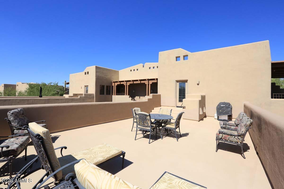 36601 North Mule Train Road, Unit 13D Carefree, AZ 85377 - Photo 45 of 51 a view of a patio with dining table and chairs with wooden fence