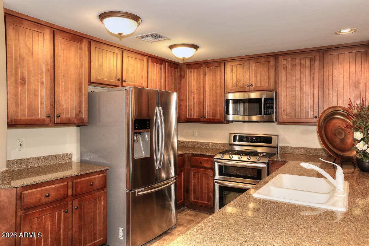 36601 North Mule Train Road, Unit 13D Carefree, AZ 85377 - Photo 5 of 51 a kitchen with stainless steel appliances granite countertop a refrigerator stove and microwave