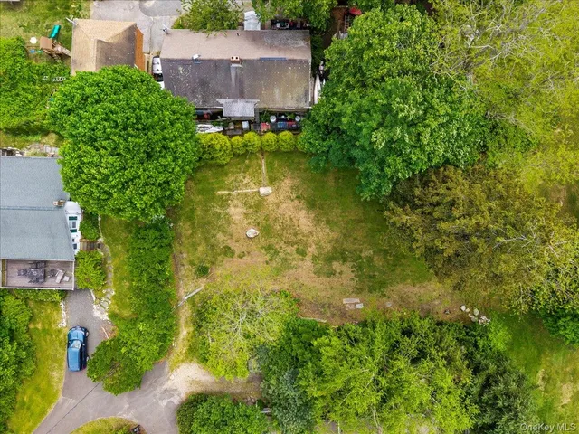 an aerial view of residential house with swimming pool and large trees