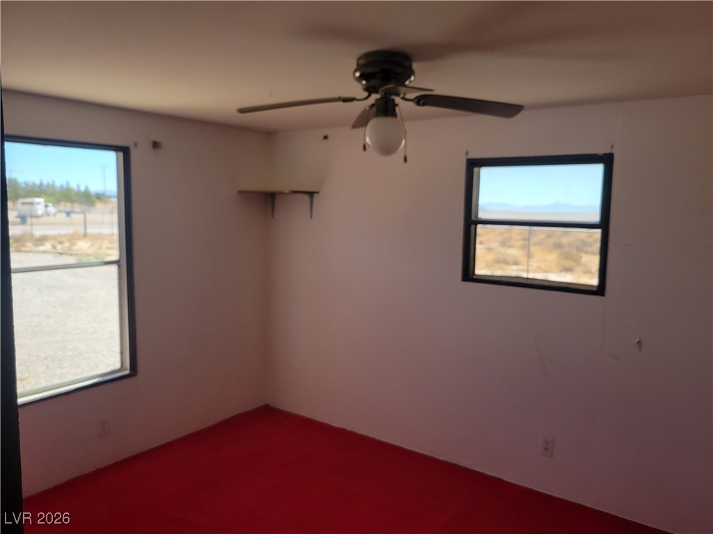7950 South Wildhorse Road Pahrump, NV 89061 - Photo 18 of 28 Carpeted spare room featuring a ceiling fan