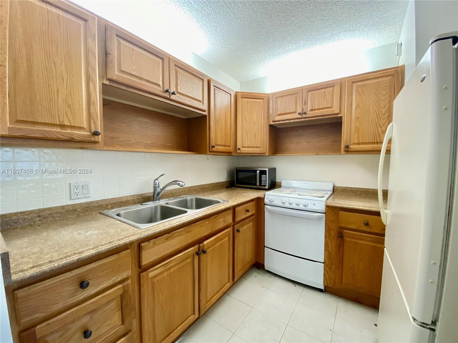 a kitchen with a sink cabinets and a refrigerator