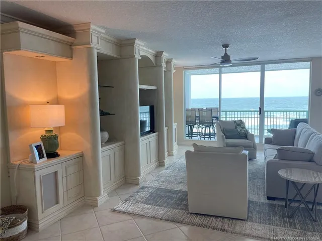 a living room with furniture and a floor to ceiling window