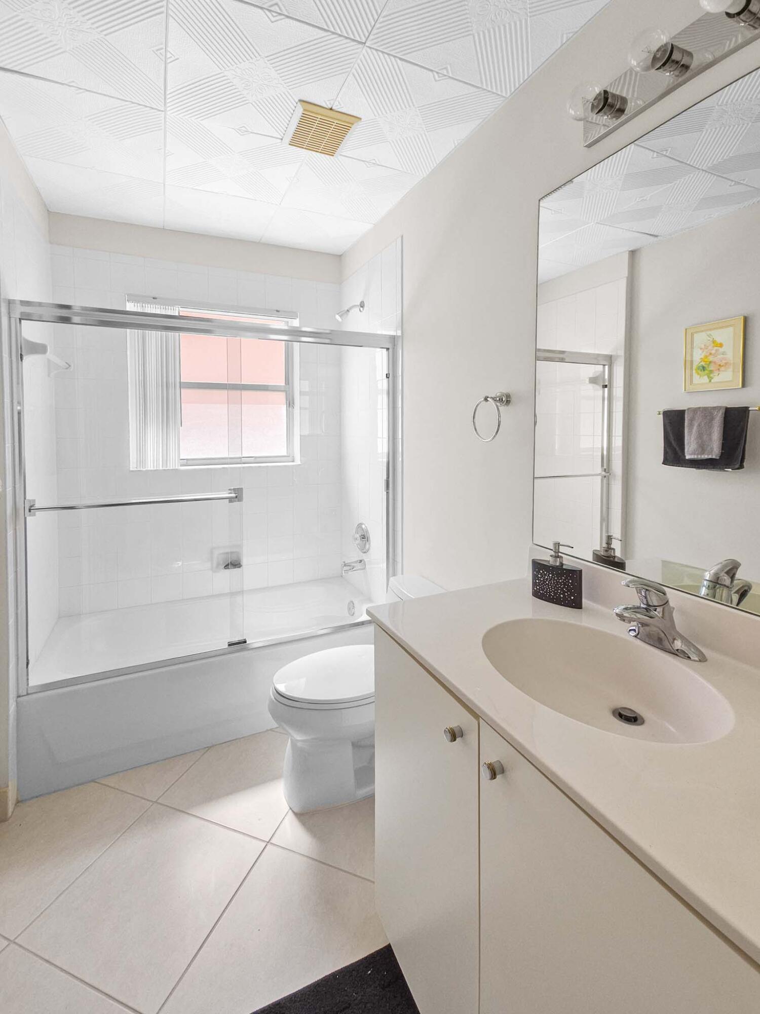 11853 Grove Ridge Lane Boynton Beach, FL 33437 - Photo 5 of 59 a bathroom with a sink a toilet and bathtub