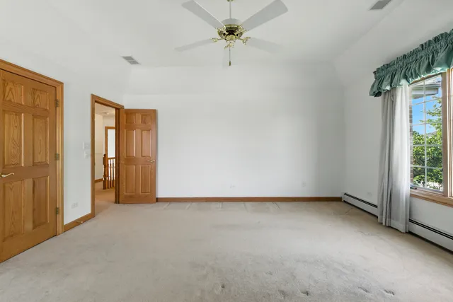 an empty room with chandelier fan