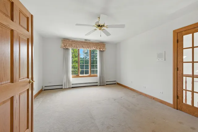 an empty room with windows and fan