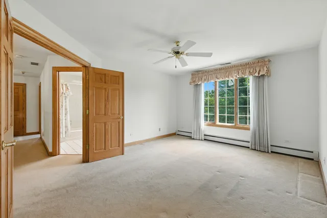 an empty room with windows and closet area