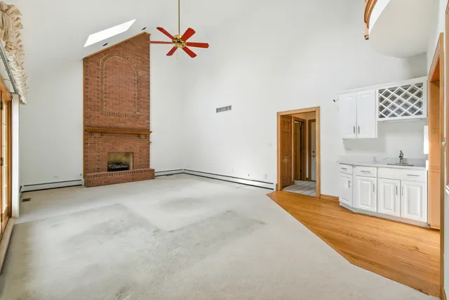 an empty room with a fireplace and chandelier