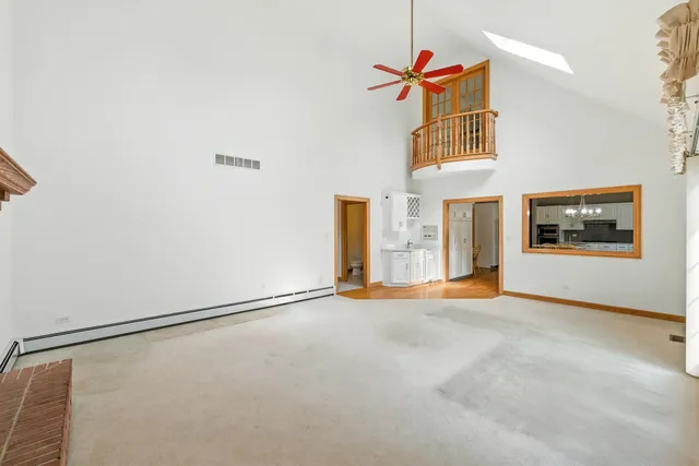 an empty room with windows and fireplace