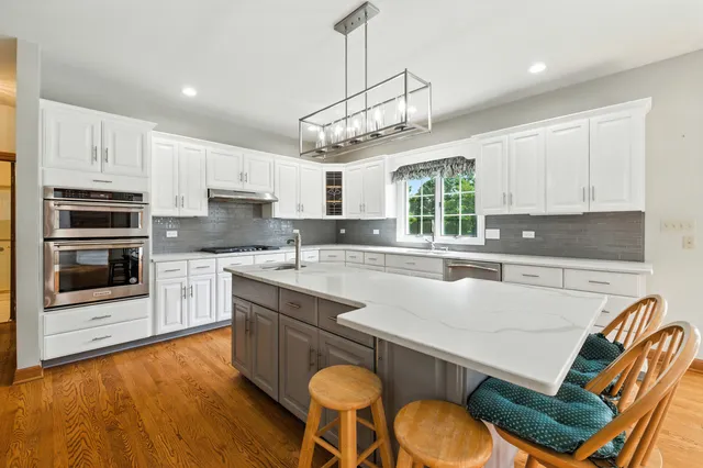 a kitchen with stainless steel appliances granite countertop a stove a sink a microwave a center island and cabinets