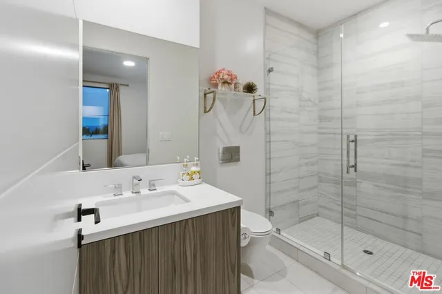 a bathroom with a sink mirror and shower