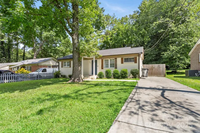 a front view of a house with a yard and potted plants