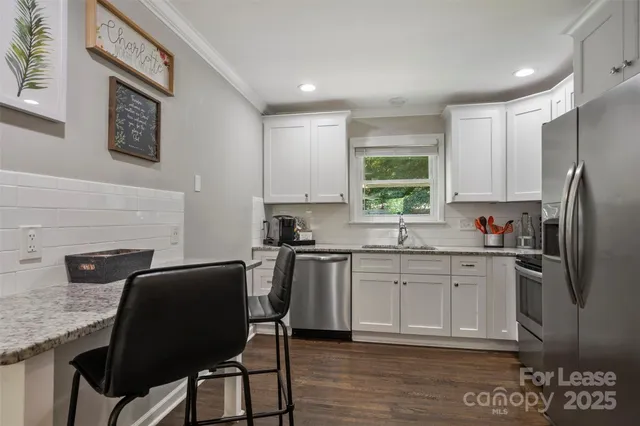 a kitchen with stainless steel appliances granite countertop a stove refrigerator sink and cabinets