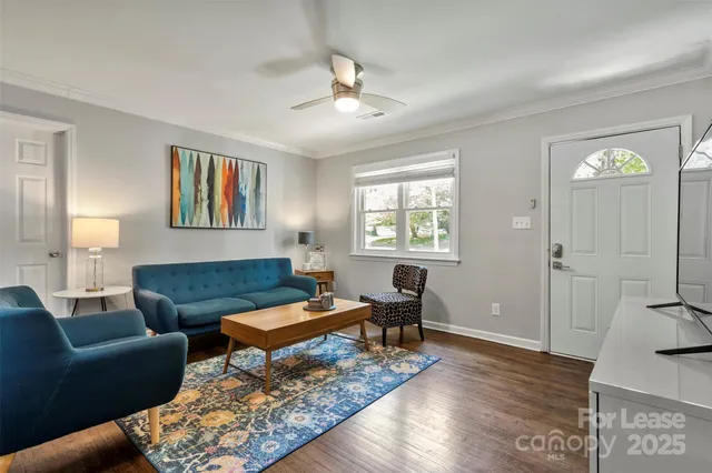 a living room with furniture and a wooden floor