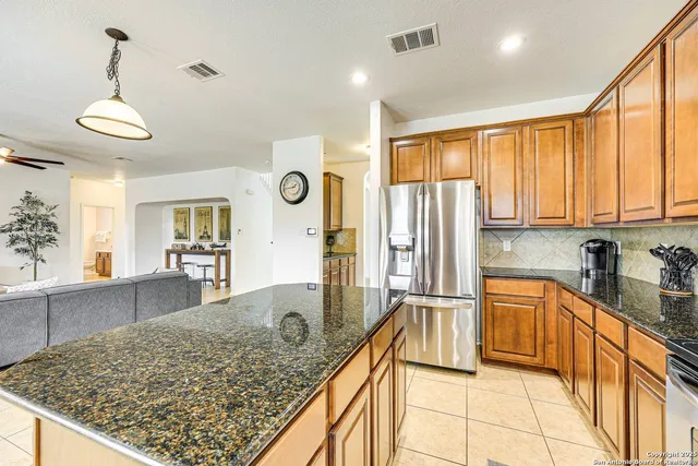 a kitchen with stainless steel appliances granite countertop a refrigerator and stove