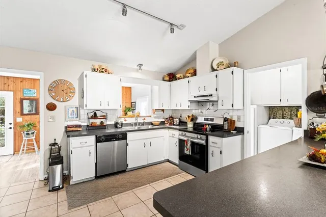 a kitchen with stainless steel appliances and white cabinets