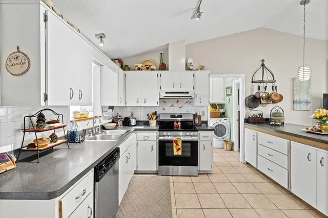 a kitchen with a sink a stove and cabinets