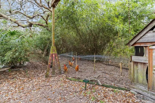 a view of a wooden house with a large tree and wooden fence