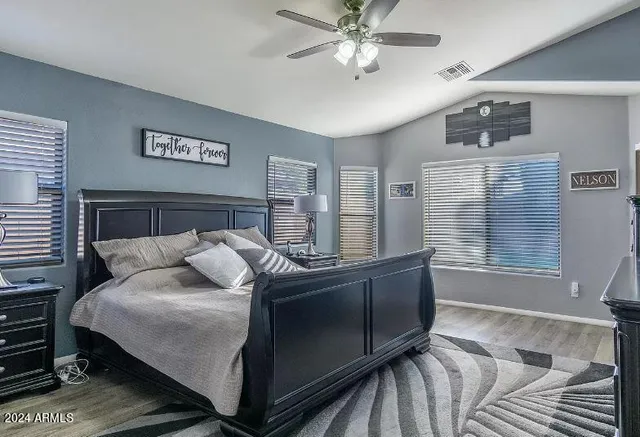 a bedroom with a bed and wooden floor