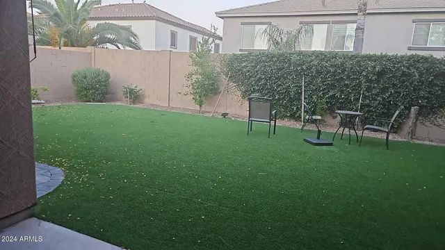 a view of a chair and table in backyard of the house