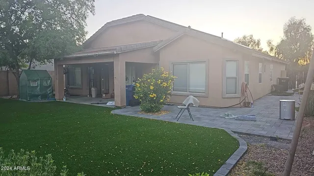 a view of a chair and table in backyard of the house