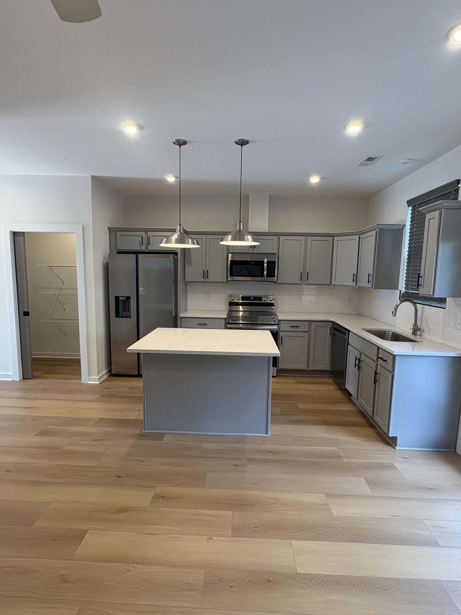 609 Wallace Road Nashville, TN 37211 - Photo 13 of 38 a large kitchen with stainless steel appliances kitchen island a stove a sink dishwasher a refrigerator and white cabinets with wooden floor
