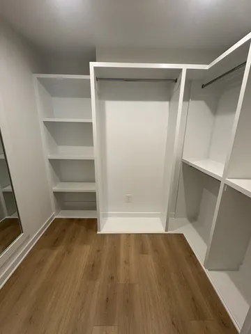 a view of walk in closet with wooden floor