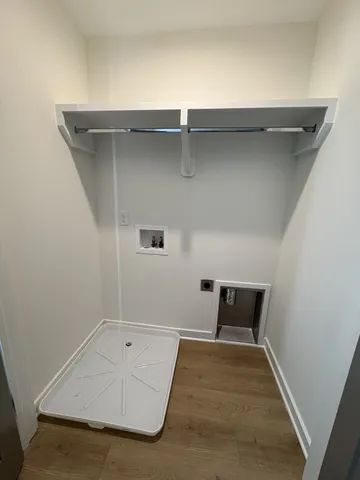 an empty room with wooden floor and cabinet