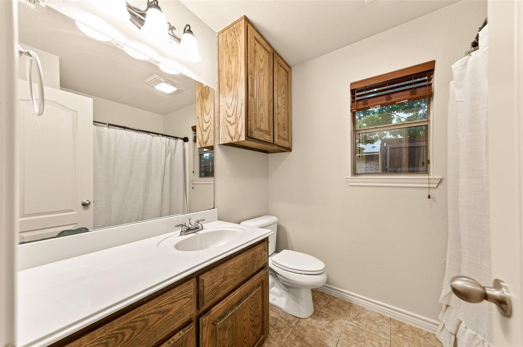 2105 Ridgewood Drive Bridgeport, TX 76426 - Photo 24 of 27 Bathroom featuring a wood-finish oversized vanity with an integrated sink, a large mirror, and tiled flooring