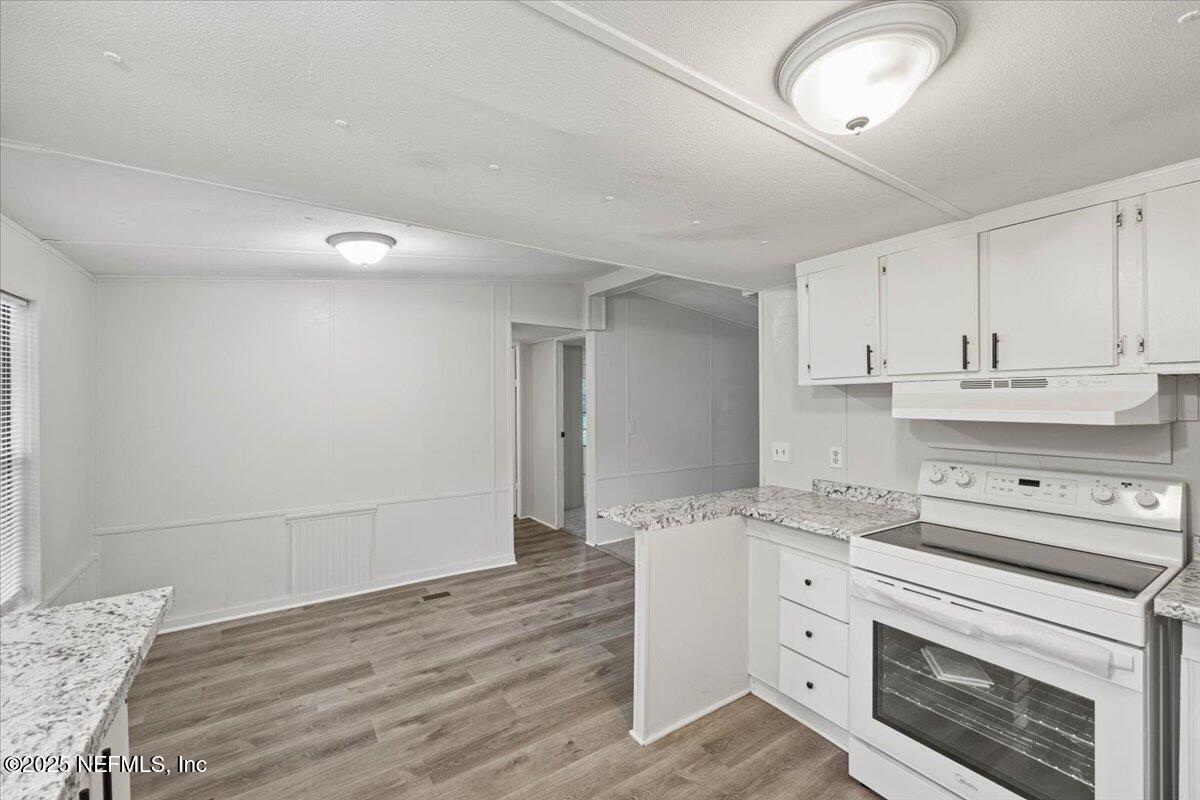 1480 Brangus Road Middleburg, FL 32068 - Photo 11 of 24 a kitchen with granite countertop white cabinets and white appliances