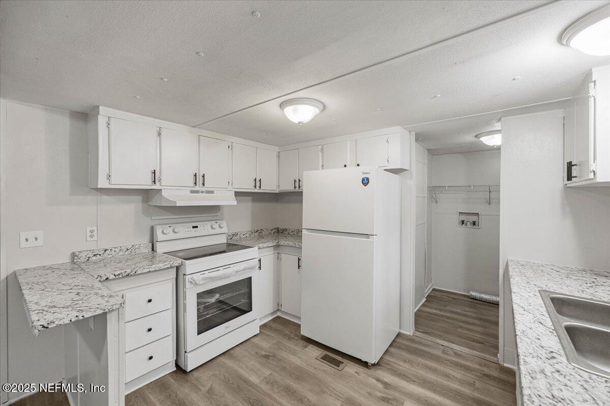 1480 Brangus Road Middleburg, FL 32068 - Photo 9 of 24 a kitchen with white cabinets and white appliances