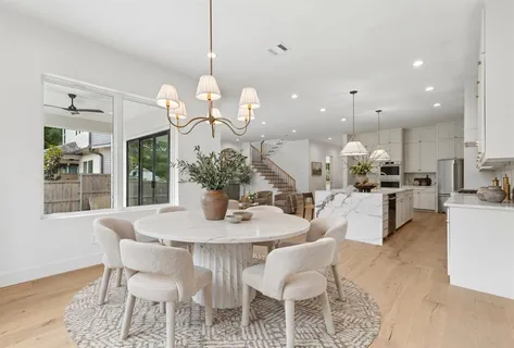 a dining room filled chandelier and kitchen view