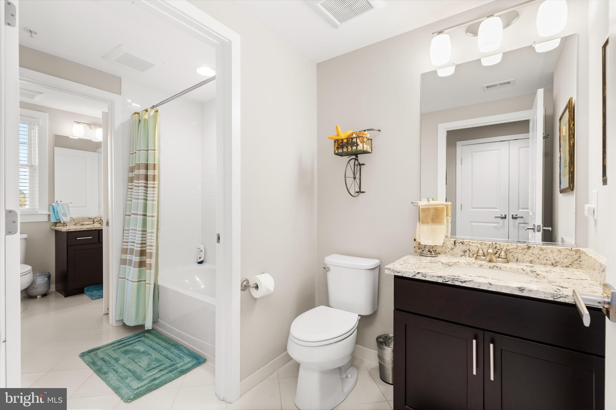 37286 Lighthouse Road, Unit 210 Selbyville, DE 19975 - Photo 29 of 75 a bathroom with a sink a toilet a mirror and shower