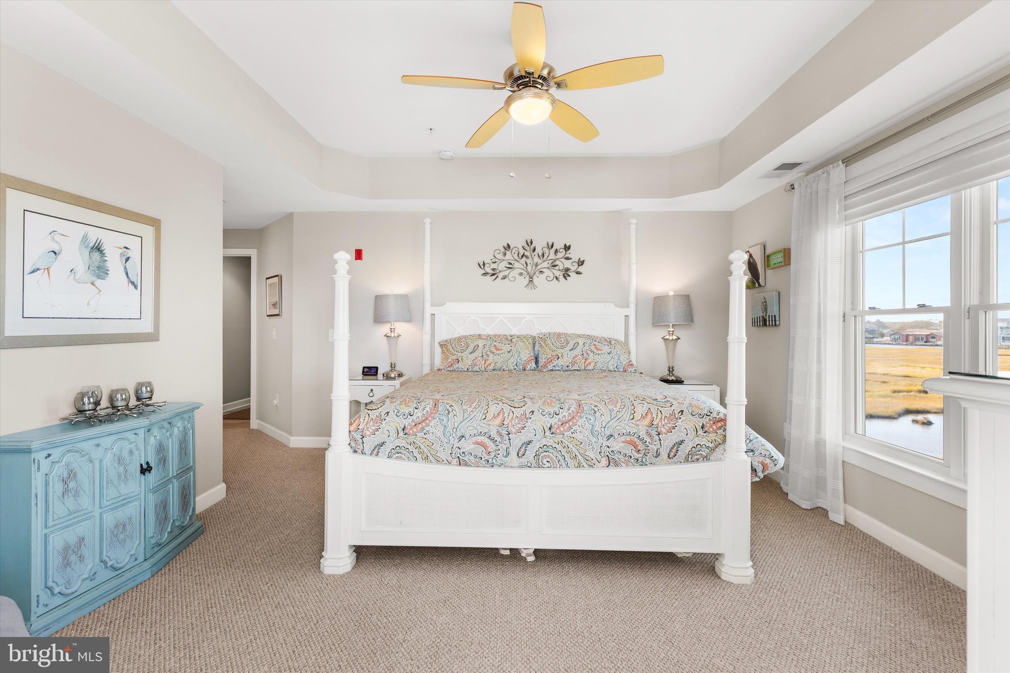 37286 Lighthouse Road, Unit 210 Selbyville, DE 19975 - Photo 41 of 75 a bedroom with a large bed and a chandelier fan