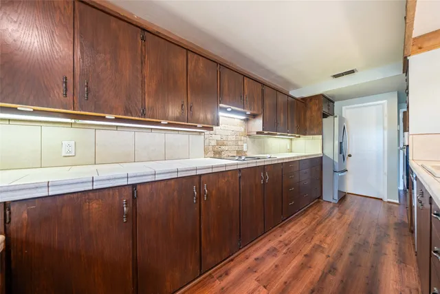 a kitchen with granite countertop wooden cabinets and a sink