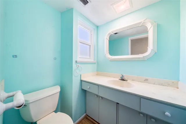 a bathroom with a sink mirror and toilet