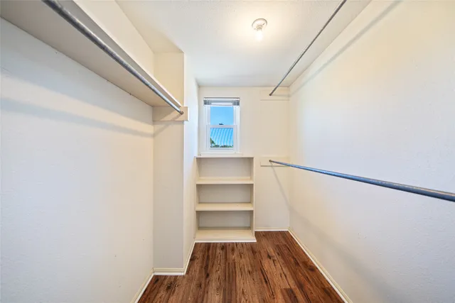 a view of walk in closet with empty racks