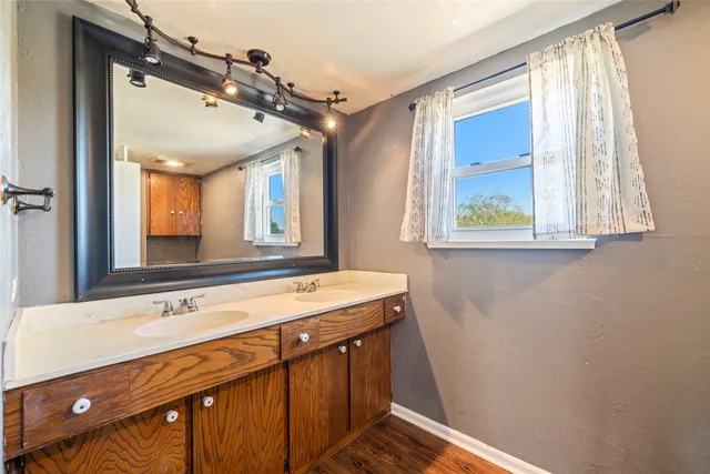 a bathroom with a sink a large mirror and a bathtub