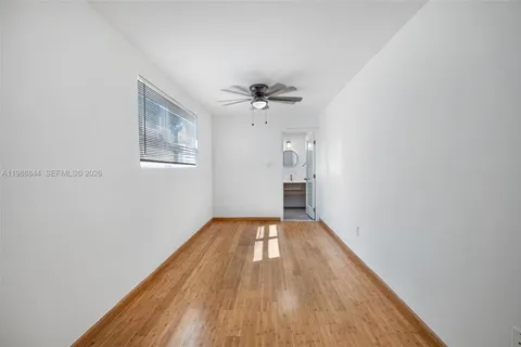 a view of an empty room with closet and wooden floor