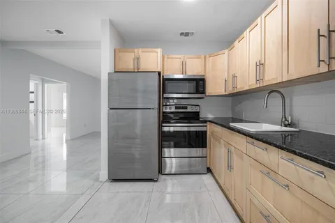 a kitchen with stainless steel appliances granite countertop a refrigerator and a sink