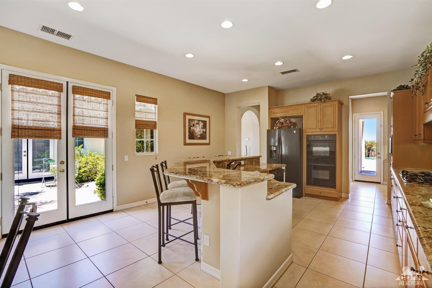 329 Loch Lomond Road Rancho Mirage, CA 92270 - Photo 16 of 50 a view of a kitchen with furniture and a refrigerator