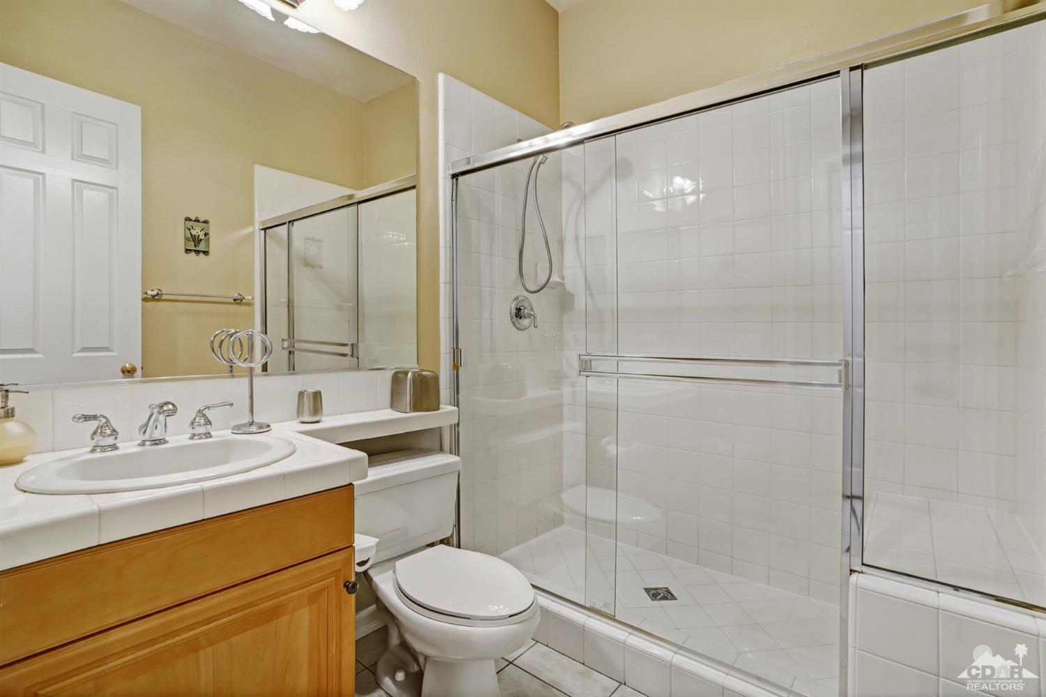 329 Loch Lomond Road Rancho Mirage, CA 92270 - Photo 29 of 50 a bathroom with a shower a sink a toilet and mirror