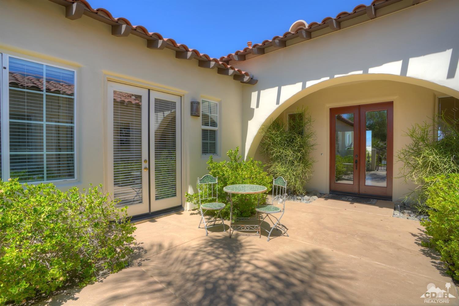 329 Loch Lomond Road Rancho Mirage, CA 92270 - Photo 5 of 50 a view of a house with potted plants next to a road