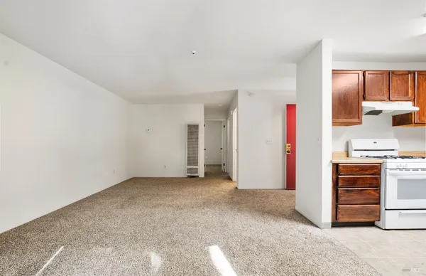 a kitchen with granite countertop a sink a stove and refrigerator