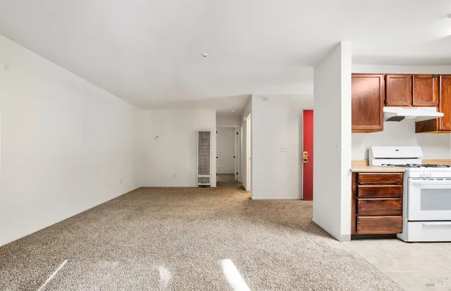 a kitchen with granite countertop a sink a stove and refrigerator