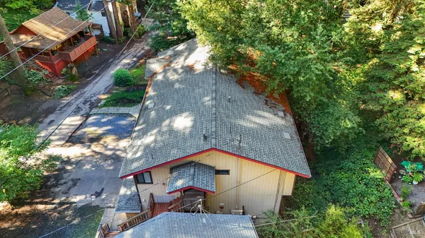an aerial view of a house with a yard and large tree