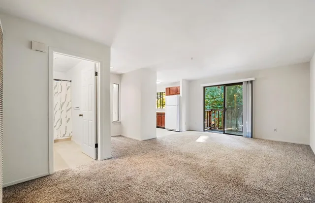 a view of an empty room with a kitchen