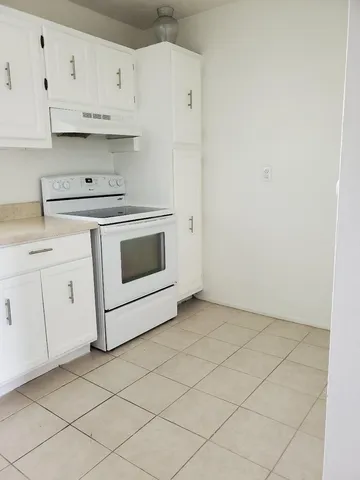 a kitchen with granite countertop white cabinets and white appliances