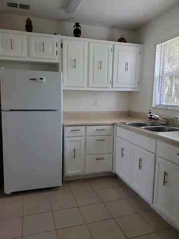 a kitchen with cabinets appliances a sink and a window